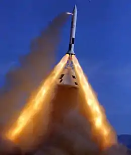 Pad Abort Test number 2. A capsule is suspended underneath a rocket section with three exhaust plumes
