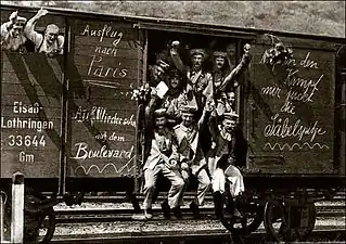 German soldiers in a railroad car on the way to the front in 1914. It is unknown if the soldiers' enthusiasm is genuine or if the scene was staged for propaganda purposes.